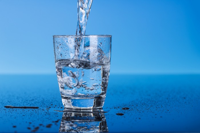 Drinking water is poured into a glass