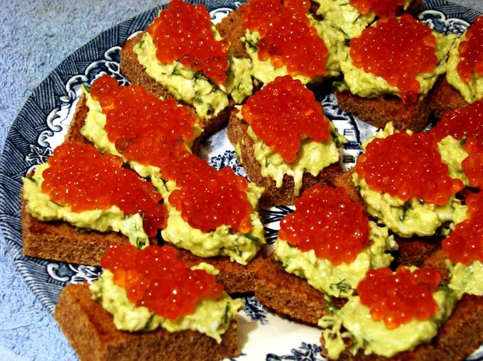 Canapes mit Paste aus Avocado und Lachs Kaviar.