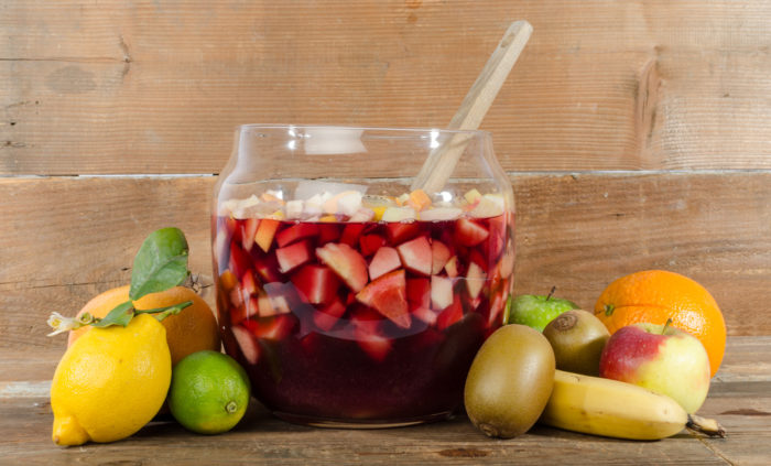 Sangria punch bowl with fruits on wooden background