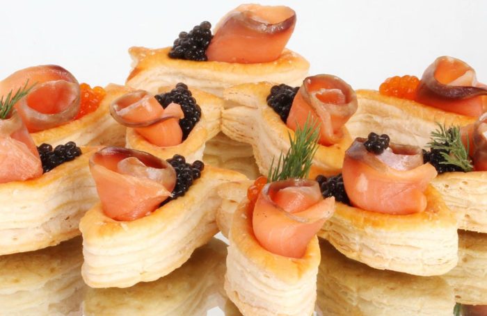 Tartlets de erupción para una ribete con caviar negro, pescado y eneldo