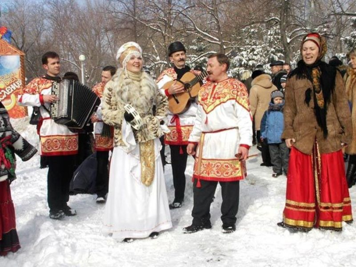 люди в национальных костюмах поют песни на Масленицу