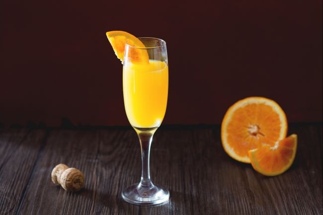 Cocktail mit Sekt und orangefarbener Mimosa-Saft