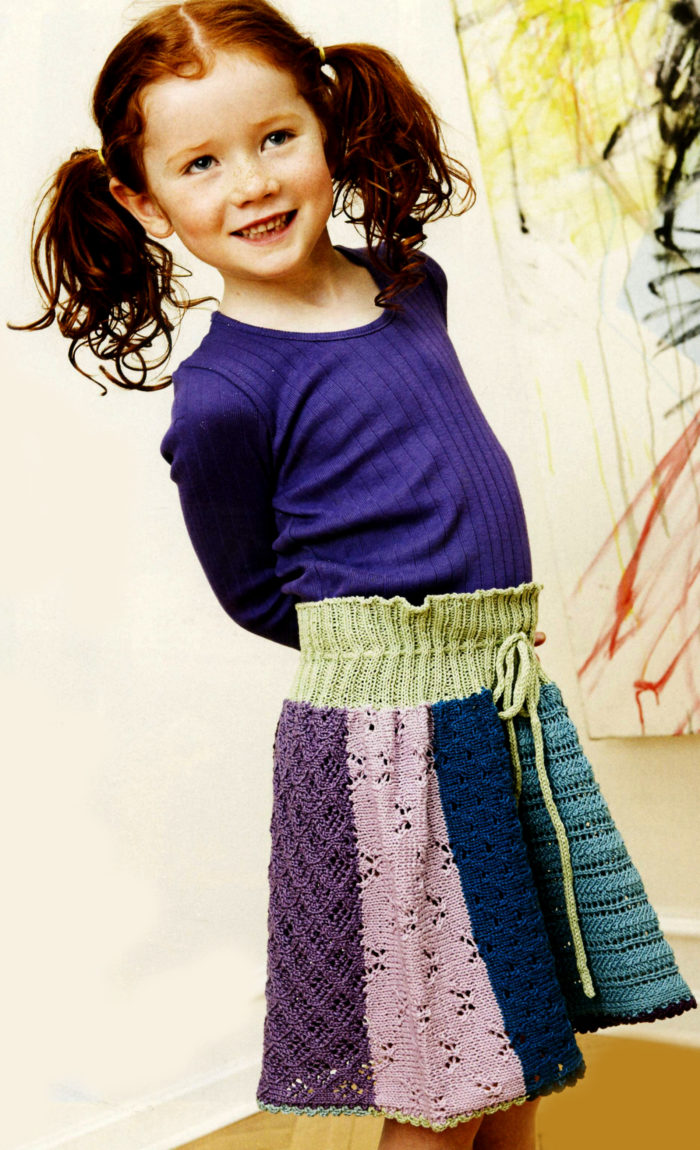 длинная разноцветная юбка, выпоненная спицами, на улыбчивой девочке