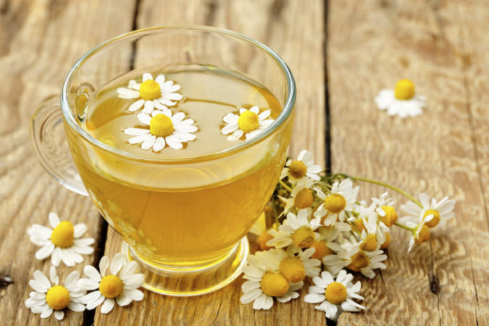 cup of chamomile tea with chamomile flowers