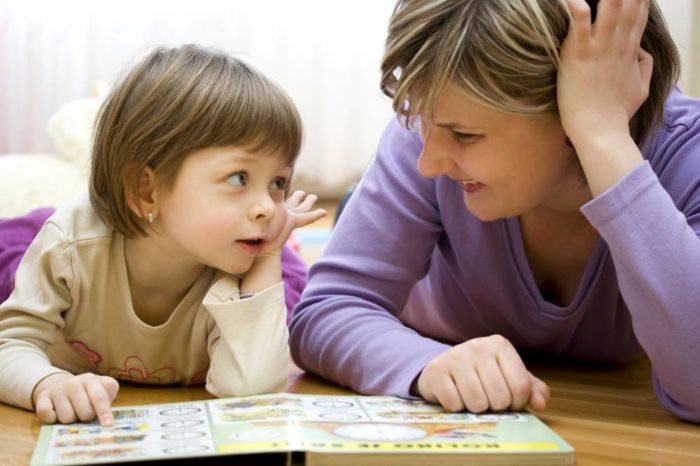 мама с дочкой лежат на полу у раскрытой книжки и разучивают слова с буквой "р"