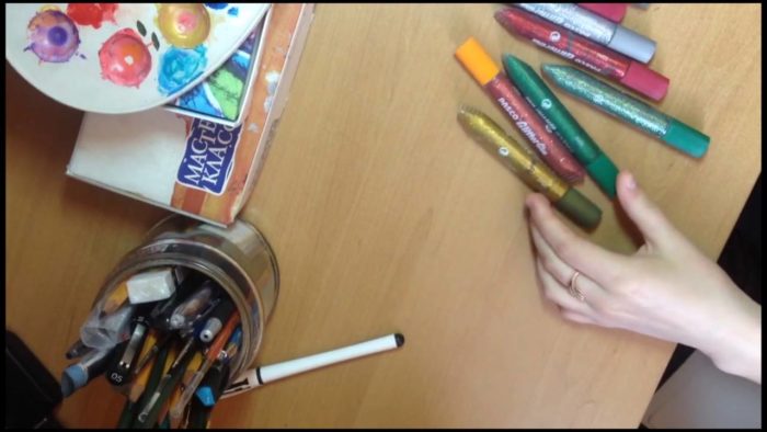 краски, фломастеры и ручки на столе у девушки перед рисованием стенгазеты для ребенка
