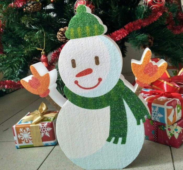 cheerful snowman made of ceiling tiles under the Christmas tree