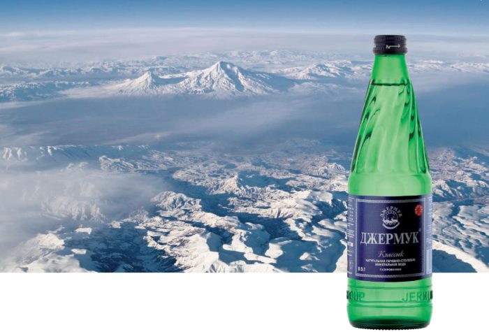 bottiglia di acqua minerale sullo sfondo di colline coperte di neve