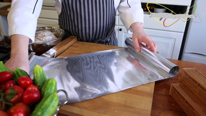 повар отмотал лист фольги для укладывания мяса перед запеканием
