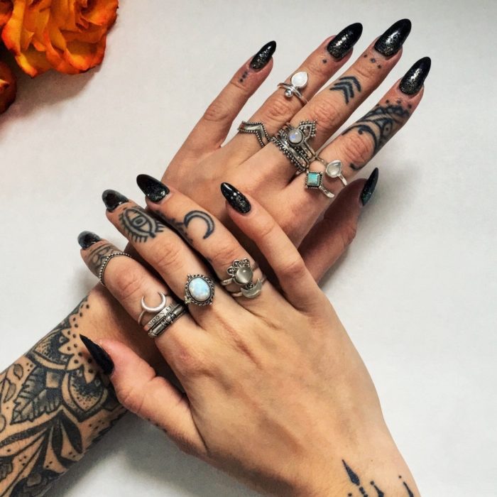 Обширные татуировки на пальцах и кисту у женщины