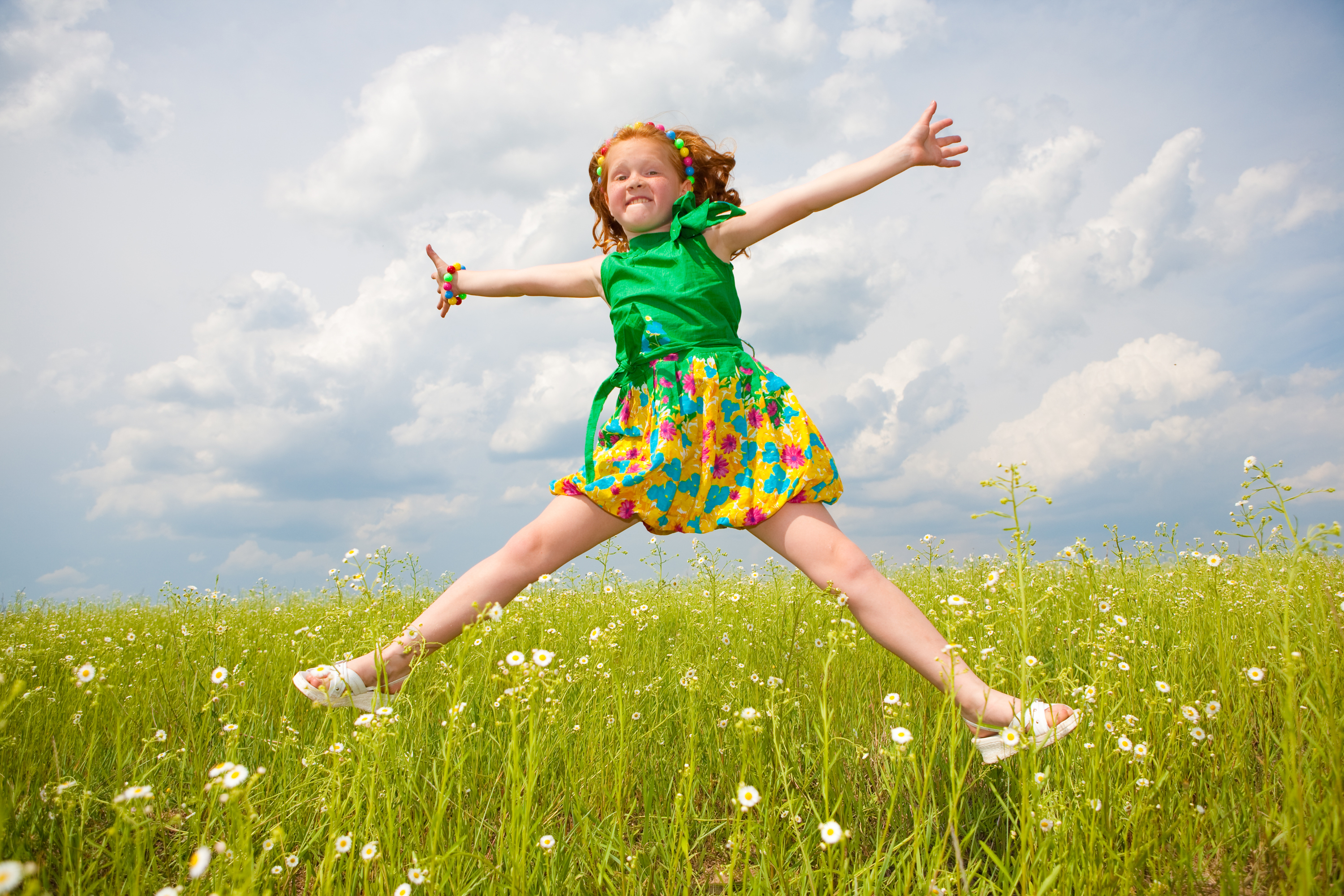 Little girl jumping against beautiful sky